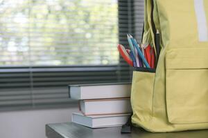 scuola forniture su di legno tavolo nel caldo interno, scuola libri su tavolo, formazione scolastica concetto. foto