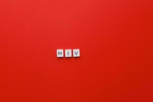 hiv giorno. AIDS giorno. in modo piatto iscrizione hiv a partire dal di legno lettere su un' rosso sfondo foto