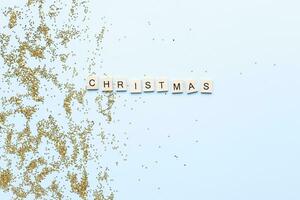 piatto posare parola Natale a partire dal di legno lettere su luccica. splendore. stella paillettes foto