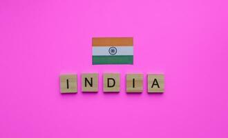 agosto 15, indipendenza giorno nel India, bandiera di India, minimalista bandiera con il iscrizione nel di legno lettere su un' rosa sfondo foto