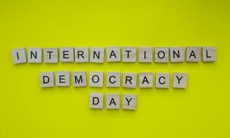 settembre 15, internazionale giorno di democrazia, minimalista bandiera con il iscrizione nel di legno lettere foto
