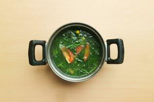 sayur baam o spinaci chiaro la minestra servire nel il pentola isolato su di legno sfondo foto