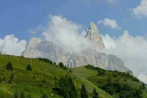 un' montagna con un' nube coperto picco nel il sfondo foto