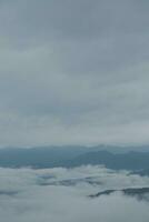 montagna gamma con visibile sagome attraverso il mattina blu nebbia. foto