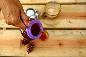 birra caffè nel un' bicchiere su un' di legno tavolo foto