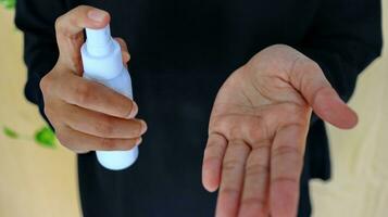 mano di signora quello l'applicazione alcool spray o antibatterico spray per impedire il diffusione di germe foto