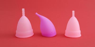 tre diverse coppette mestruali in silicone rosa riutilizzabili foto