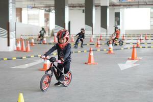 depok-indonesia, 29 07 2023 - indonesiano bambini a partire dal 2-5 anni vecchio gare su equilibrio bicicletta nel un' parcheggio la zona, sportività formazione foto