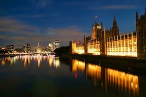 bellissimo metraggio di illuminato fiume Tamigi a Londra occhio a partire dal Westminster, grande Ben orologio Torre a dopo tramonto notte. Inghilterra grande Gran Bretagna, metraggio era catturato su ago 02, 2023 foto