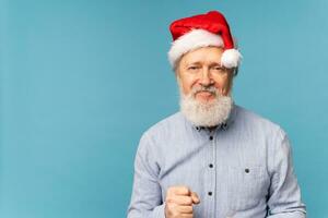 contento fiducioso freddo vecchio barbuto Santa Claus vincitore raccolta cazzotto festeggiare trionfo e successo al di sopra di blu sfondo con copia spazio foto