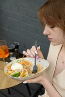 giovane donna godendo il gusto di quinoa e salmone insalata foto