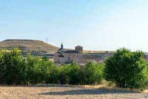 romanico cattolico pietra Chiesa nel villaggio sotto blu cielo foto