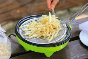 francese patatine fritte cucinando su in profondità friggitrice. foto