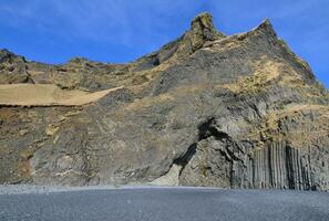 basalto colonne trovato su nero sabbia spiaggia nel vik Islanda foto
