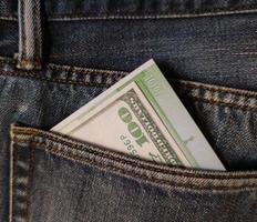 cento dollari e cento euro nella tasca posteriore dei jeans. foto