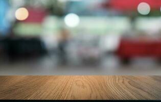 vuoto di legno tavolo nel davanti di astratto sfocato sfondo di caffè negozio . può essere Usato per Schermo o montaggio il tuo prodotti.mock su per Schermo di Prodotto foto