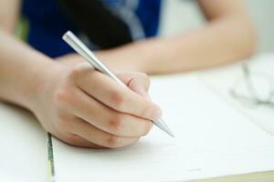 asiatico adolescenziale alunno Scrivi compiti a casa, studia lezione per esame in linea apprendimento formazione scolastica. foto