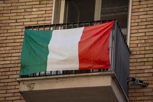 bandiera italiana appesa a una finestra foto