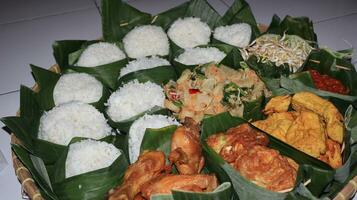 indonesiano vario cibo per ringraziamento. indonesiano chiamata esso nasi berkat foto