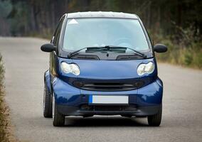 poco blu auto guida su il strada, moderno città auto sfondo foto