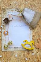 un' carta con un' Natale Messaggio e un' penna su un' Marrone sfondo foto