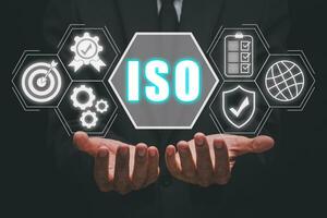 iso standard qualità controllo concetto, persona mano Tenere iso icona su virtuale schermo su scrivania posto di lavoro, garanzia garanzia, attività commerciale tecnologia concetto. foto