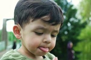 carino asiatico pakistano bambino è godendo il bellissimo soleggiato giorno a guerra bambini e pubblico parco di luton cittadina di Inghilterra UK. Basso angolo Immagine era catturato su aprile 03, 2023 foto