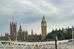 bellissimo Basso angolo Visualizza di storico grande Ben orologio Torre a partire dal fiume Tamigi e Londra occhio, Westminster centrale Londra, Inghilterra grande Gran Bretagna, UK. Immagine catturato durante nuvoloso giorno di agosto 2°, 2023 foto