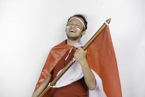 contento sorridente indonesiano uomo Tenere dell'Indonesia bandiera per celebrare Indonesia indipendenza giorno isolato al di sopra di bianca sfondo. foto