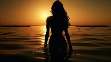 un' donna è ammirazione sua riflessione nel il luce del sole su il mare. silhouette concetto foto