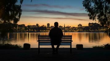 uomo seduta su lago merritt panchina con il computer portatile. silhouette concetto foto