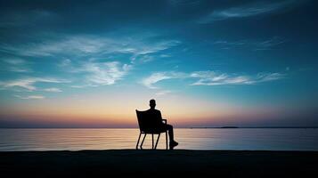 il uomo seduto mare. silhouette concetto foto