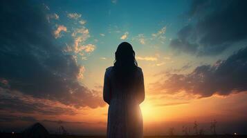 donna preghiere con cielo sfondo. silhouette concetto foto