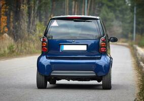 poco blu auto guida su il strada, moderno città auto sfondo foto