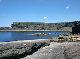 scogliere e atlantico oceano, nuvole, rocce e laguna, bellezza nel natura. vacanza viaggio rilassamento sfondo foto