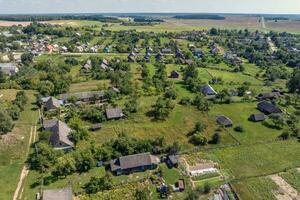 panoramico aereo Visualizza di eco villaggio con di legno case, ghiaia strada, giardini e frutteti foto