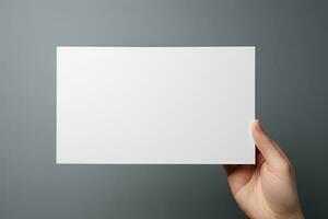 un' umano mano Tenere un' vuoto foglio di bianca carta o carta isolato su grigio sfondo. ai generato foto