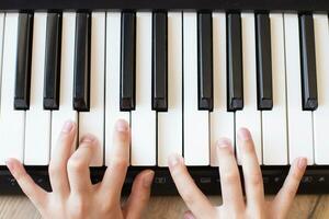 bambino mani è giocando, apprendimento e praticante il pianoforte. pianoforte accordi nel il chiave. foto