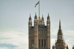 bellissimo Basso angolo Visualizza di storico grande Ben orologio Torre a partire dal fiume Tamigi e Londra occhio, Westminster centrale Londra, Inghilterra grande Gran Bretagna, UK. Immagine catturato durante nuvoloso giorno di agosto 2°, 2023 foto