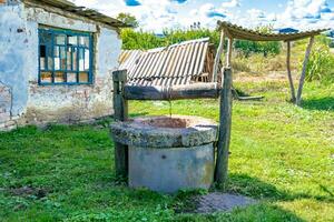 vecchio bene con ferro secchio su lungo forgiato catena per pulito potabile acqua foto