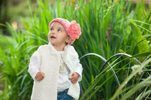 dolce anno e un' metà bambino ragazza a il giardino nel un' bellissimo soleggiato giorno foto