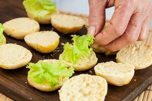 passo di passo preparazione di mini hamburger. fatti in casa mini hamburger per bambini o Antipasti. piccolo hamburger. assemblaggio hamburger foto