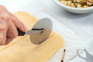 ravioli preparazione. taglio pasta Impasto in strisce foto