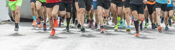 corridori nel pantaloncini e formatori inizio in esecuzione un' concorrenza, con solo loro gambe visibile. foto