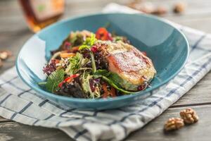 halloumi formaggio avvolto nel Bacon su un' foglia insalata nel un' blu piatto. foto