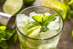 Mojito cocktail bevanda con bianca Rum lime menta erbe aromatiche e bibita su il bar contatore foto