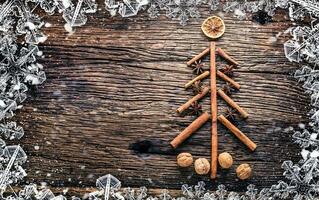 Natale albero a partire dal cannella stella anice e Noci su rustico di legno tavolo. astratto nevoso telaio foto