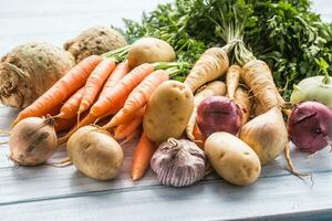 assortimento di fresco verdure su di legno tavolo. carota pastinaca aglio sedano cipolla e cavolo rapa foto