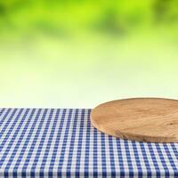 vuoto di legno Pizza tavola su blu scacchi tovaglia. foto