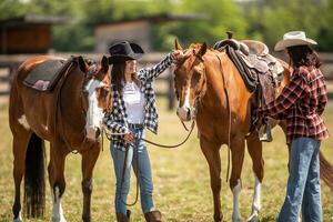 cowgirl correzioni un' sella su un' dipingere cavallo mentre sua amico aiuta sua per hold sua cavallo foto